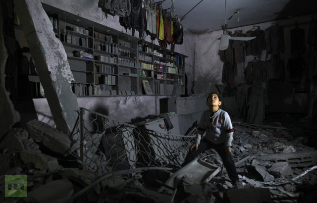 A boy looks up as he walks in the rubble of a destroyed shop in Beit Lahia, in the northern Gaza Strip, on November 26, 2012 (AFP Photo / Mahmud Hams)